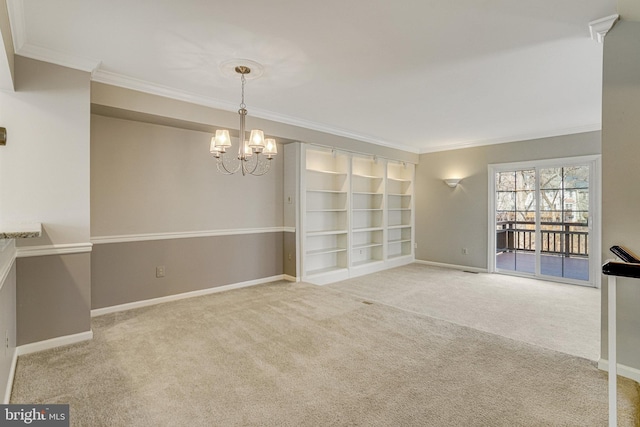 empty room featuring carpet floors, baseboards, a chandelier, and crown molding