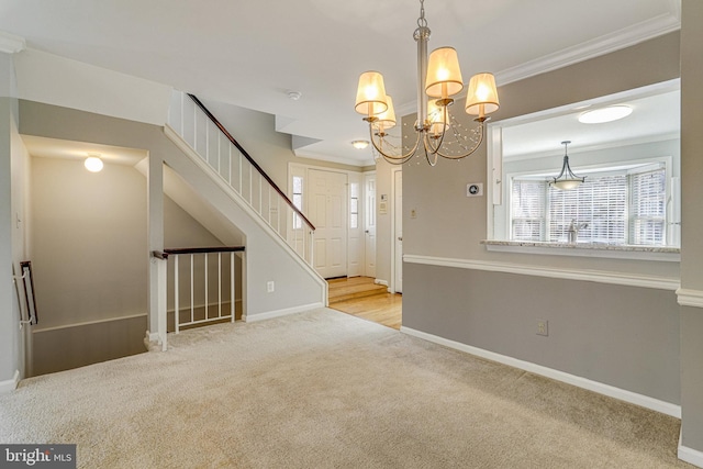 interior space with baseboards, carpet floors, an inviting chandelier, and crown molding