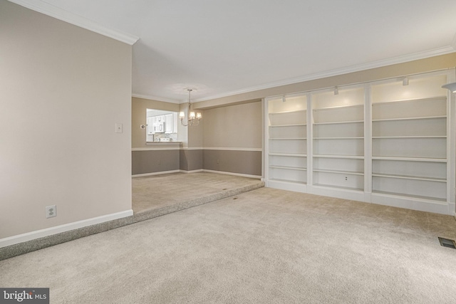 unfurnished room with ornamental molding, carpet, a notable chandelier, and baseboards