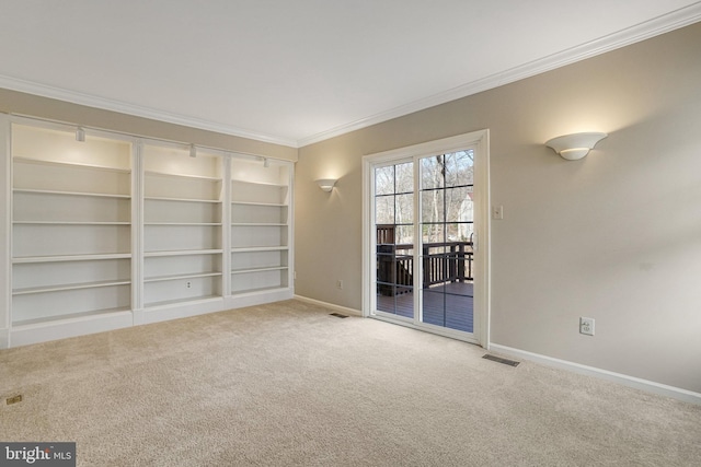 carpeted empty room with ornamental molding, visible vents, and baseboards