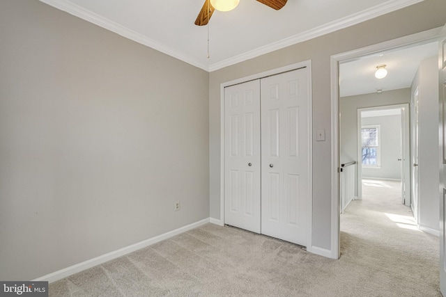 unfurnished bedroom featuring baseboards, ornamental molding, and light colored carpet