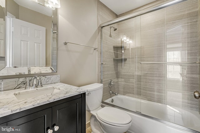 bathroom with combined bath / shower with glass door, vanity, and toilet