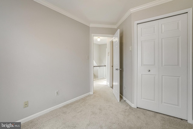 hall featuring carpet, ornamental molding, and baseboards