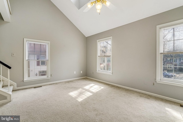 spare room featuring a healthy amount of sunlight, baseboards, stairs, and carpet floors