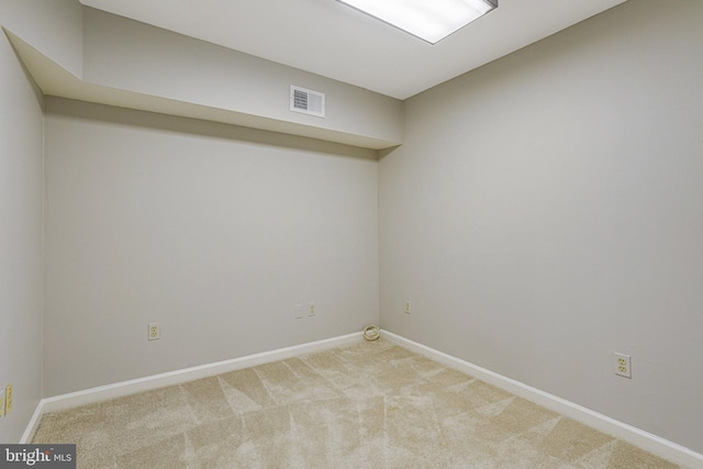 spare room featuring light carpet, baseboards, and visible vents