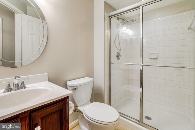 bathroom with vanity, a shower stall, and toilet