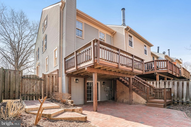 back of property with a gate, a patio area, fence, and a deck