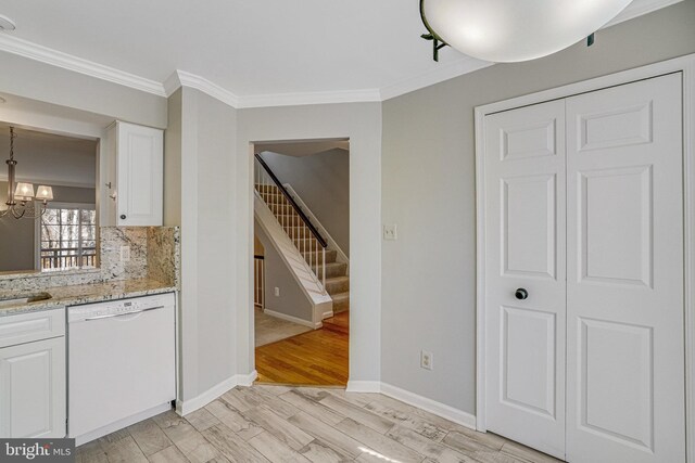 kitchen with white dishwasher, white cabinets, light wood-type flooring, decorative backsplash, and crown molding