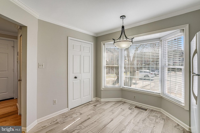 unfurnished dining area featuring crown molding, baseboards, visible vents, and light wood-style floors