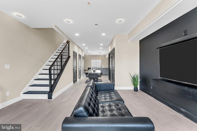 living area with light wood-style floors, recessed lighting, stairway, and baseboards