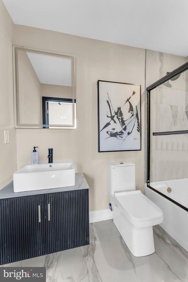 bathroom featuring toilet, marble finish floor, bath / shower combo with glass door, and vanity