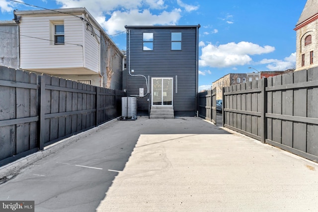 back of house featuring entry steps, a patio area, a fenced backyard, and cooling unit