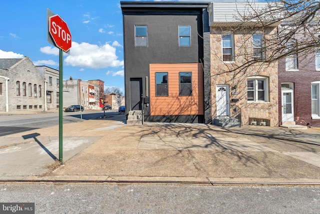 multi unit property featuring entry steps, stone siding, and a residential view