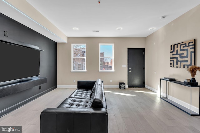 home theater room featuring wood finished floors and baseboards