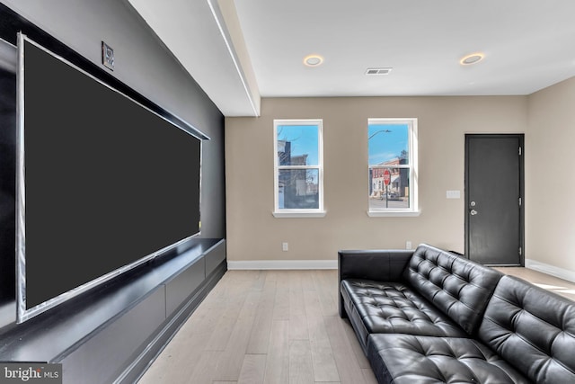 cinema with light wood-style floors and baseboards