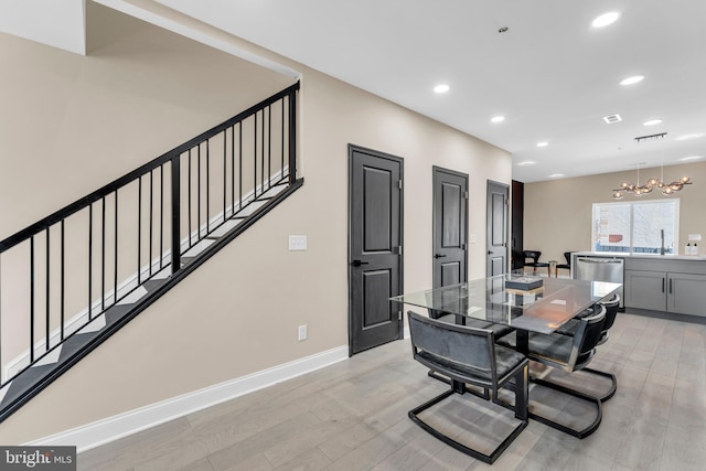 dining room featuring recessed lighting, light wood finished floors, baseboards, and stairs