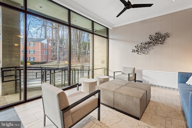 living room with crown molding, a ceiling fan, and floor to ceiling windows