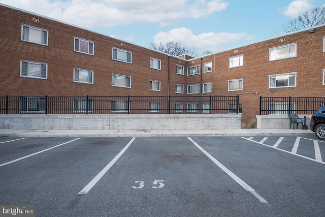 uncovered parking lot featuring fence