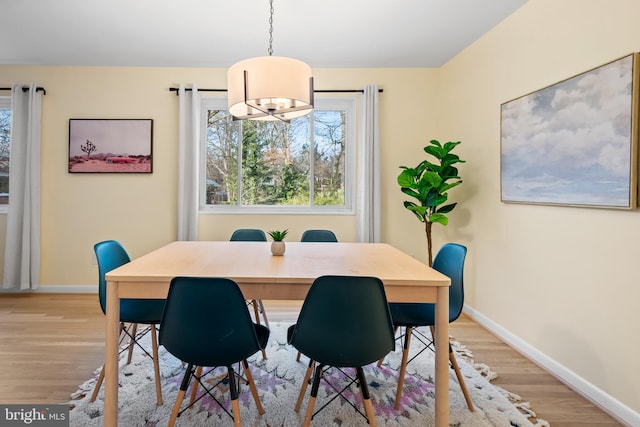 dining space featuring light wood-style flooring and baseboards