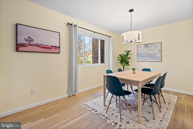 dining area with baseboards and wood finished floors