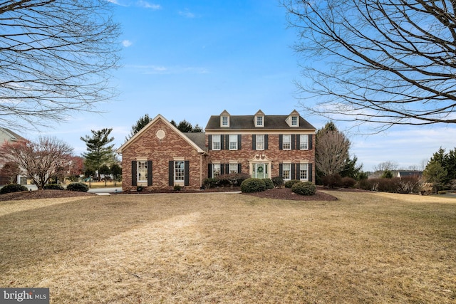 view of front of house featuring brick siding and a front lawn