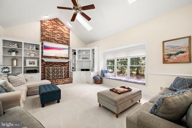 living room featuring high vaulted ceiling, a fireplace, a skylight, carpet flooring, and a ceiling fan