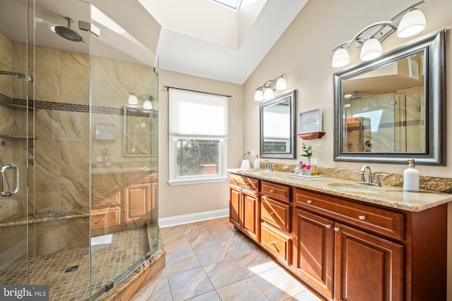 bathroom with vaulted ceiling with skylight, a sink, and a shower stall