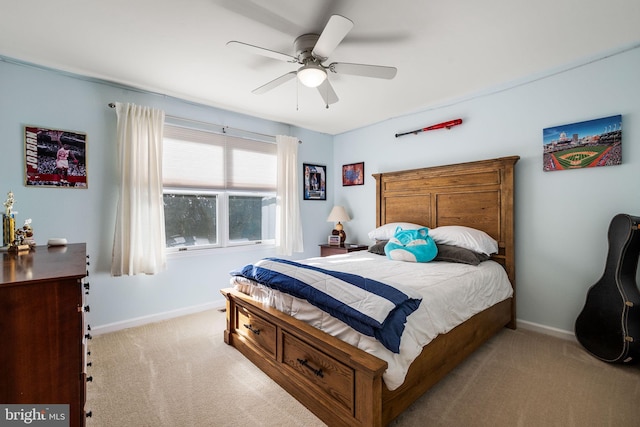 bedroom with light colored carpet, ceiling fan, and baseboards