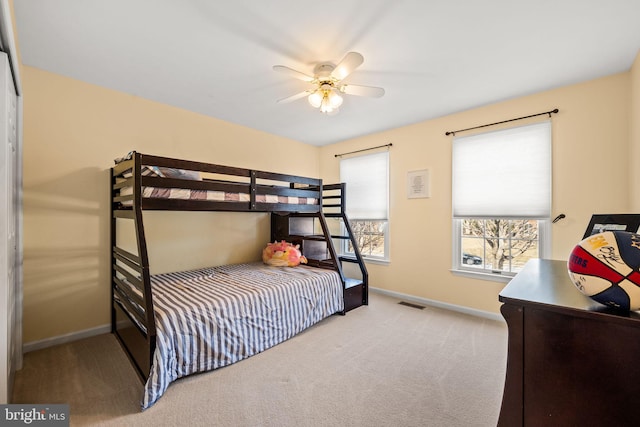 carpeted bedroom featuring baseboards, visible vents, and a ceiling fan