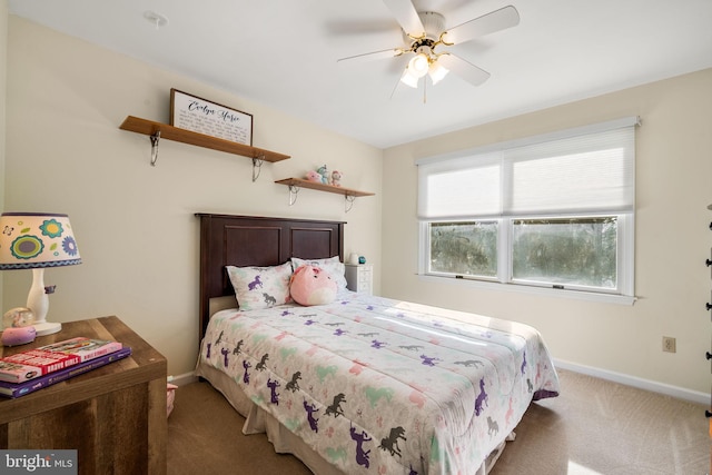 carpeted bedroom with ceiling fan and baseboards