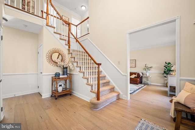 stairs featuring baseboards, ornamental molding, and wood finished floors