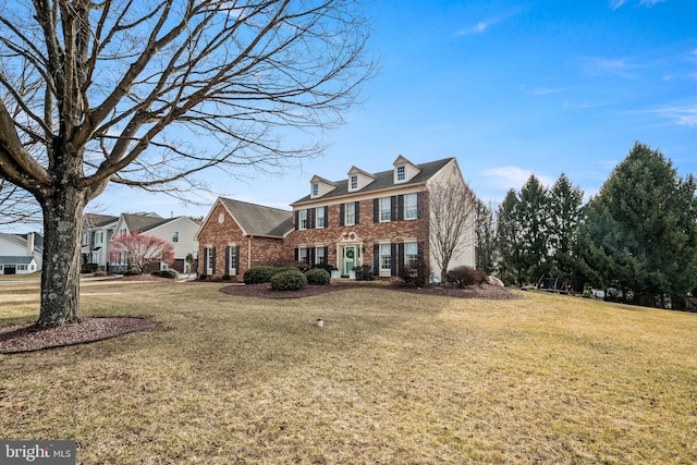 view of front facade with a front yard and brick siding