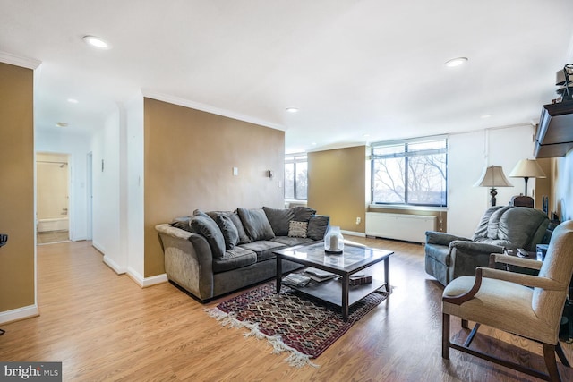 living room with light wood-type flooring, crown molding, baseboards, and recessed lighting