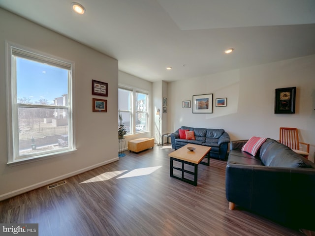 living room featuring baseboards, visible vents, wood finished floors, and recessed lighting