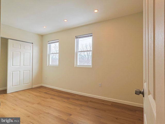 unfurnished bedroom featuring light wood-style floors, recessed lighting, a closet, and baseboards