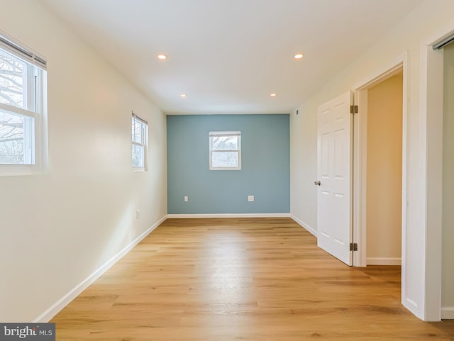 spare room featuring light wood-style floors, baseboards, and recessed lighting