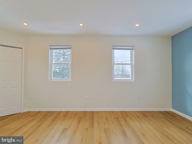 empty room featuring light wood finished floors, baseboards, and recessed lighting