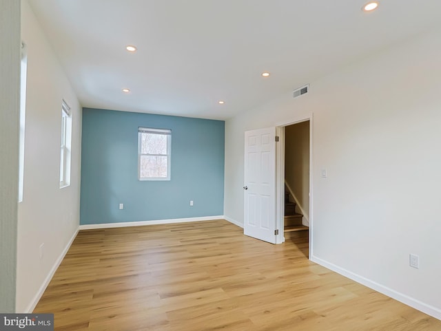 unfurnished room featuring light wood-type flooring, baseboards, visible vents, and recessed lighting