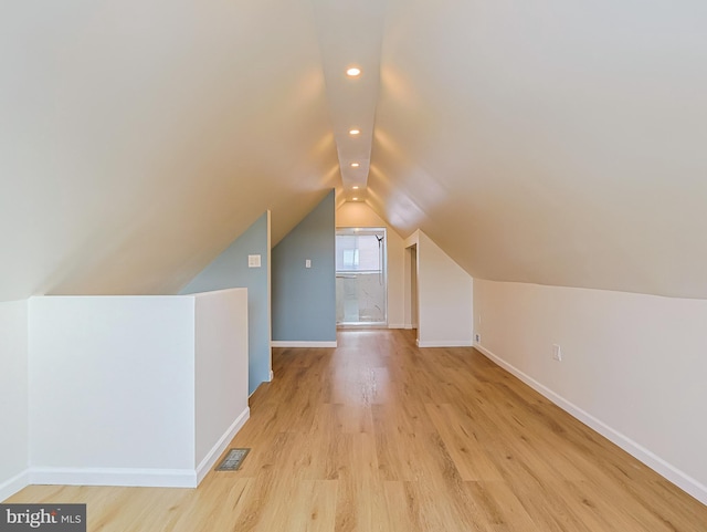 bonus room featuring light wood-style floors, lofted ceiling, visible vents, and baseboards