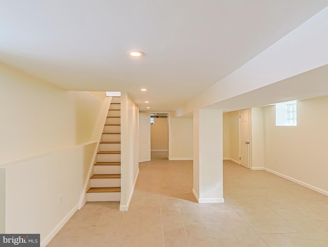 basement featuring light tile patterned floors, baseboards, stairway, and recessed lighting