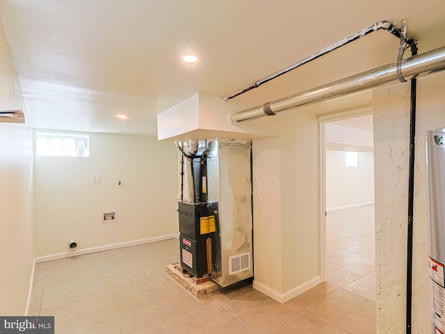 basement with gas water heater, recessed lighting, heating unit, and baseboards