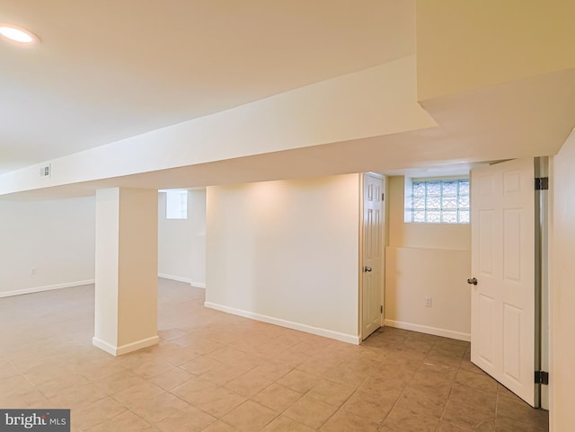 basement with light tile patterned flooring and baseboards