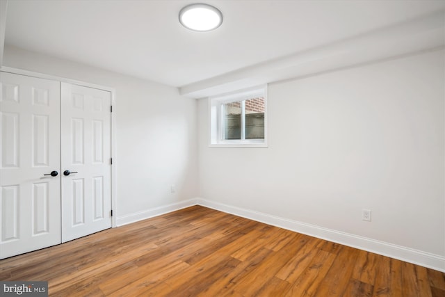 empty room with baseboards and wood finished floors