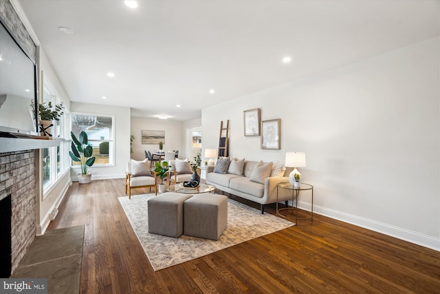 living room with recessed lighting, a fireplace, baseboards, and wood finished floors