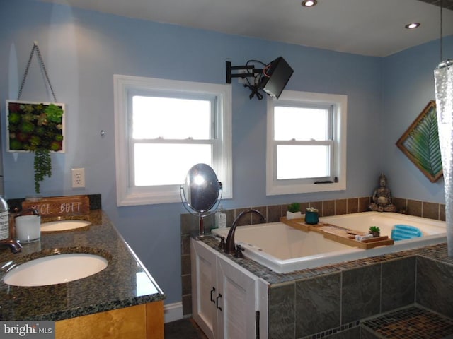 full bathroom featuring plenty of natural light, a sink, and a bath