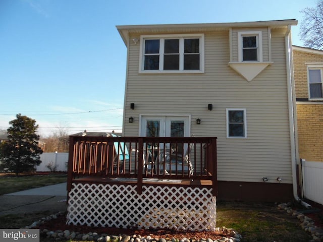 rear view of property featuring a wooden deck and fence