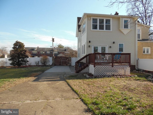 back of property featuring a gate, fence, a deck, and french doors