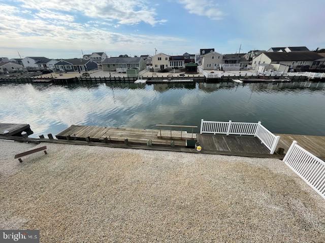 view of dock featuring a water view and a residential view