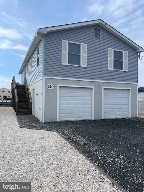 view of home's exterior featuring aphalt driveway, stairway, and a garage