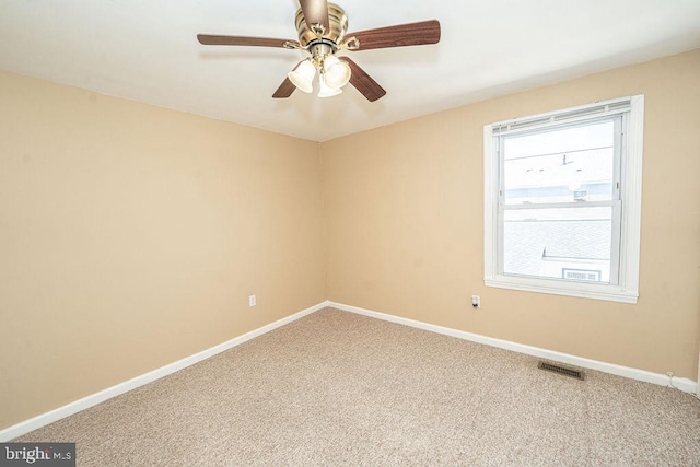 carpeted empty room with visible vents, ceiling fan, and baseboards